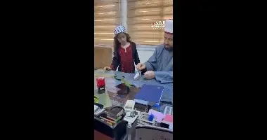 השר הפלסטיני מחמד נג'ם טובל את חרוזי התפילה בכוס מים ומגיש אותה לילדה