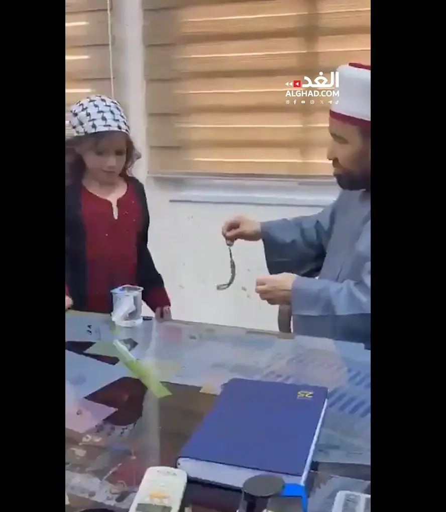 השר הפלסטיני מחמד נג'ם טובל את חרוזי התפילה בכוס מים ומגיש אותה לילדה השר הפלסטיני מחמד נג'ם טובל את חרוזי התפילה בכוס מים ומגיש אותה לילדה