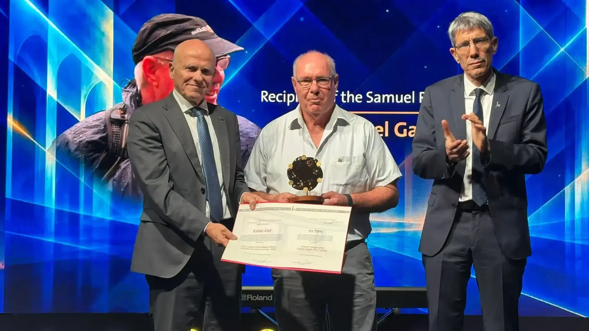 בתמונה נשיא האוני׳ העברית פרופ׳ תמיר שפר מגיש את הפרס לאשל גת על רקע מחיאות הכפיים ממקבלי תואר ד״ר לשם כבוד מטעם האוניברסיטה העברית בתמונה נשיא האוני׳ העברית פרופ׳ תמיר שפר מגיש את הפרס לאשל גת על רקע מחיאות הכפיים ממקבלי תואר ד״ר לשם כבוד מטעם האוניברסיטה העברית